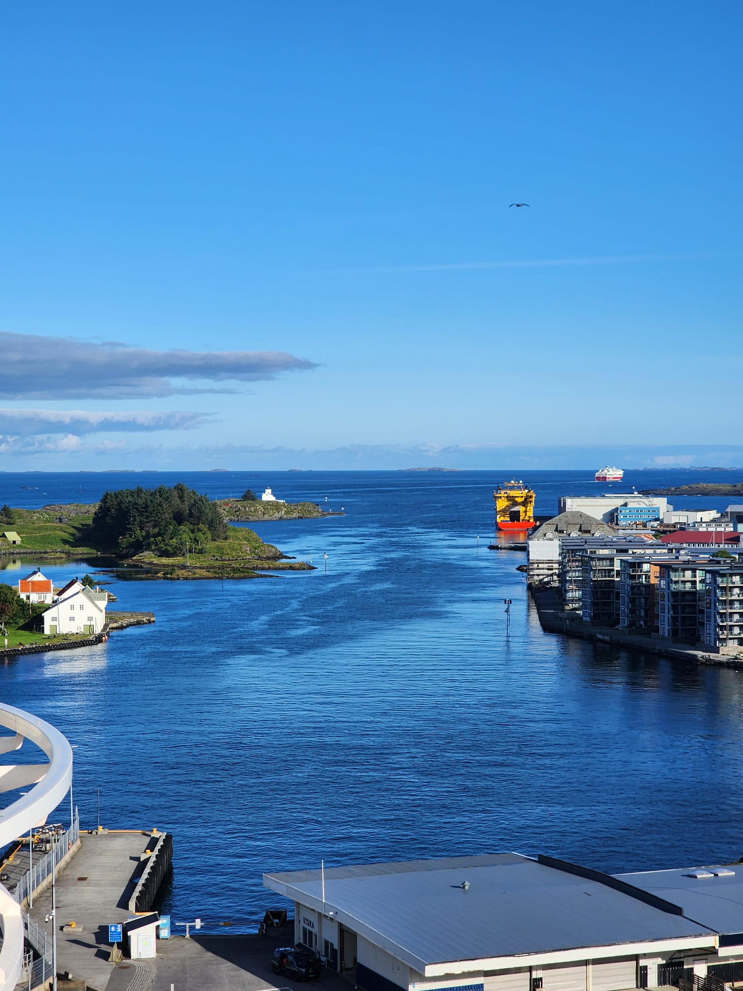 A Norwegian harbour channel with islands, a lighthouse and ships heading out to open sea
